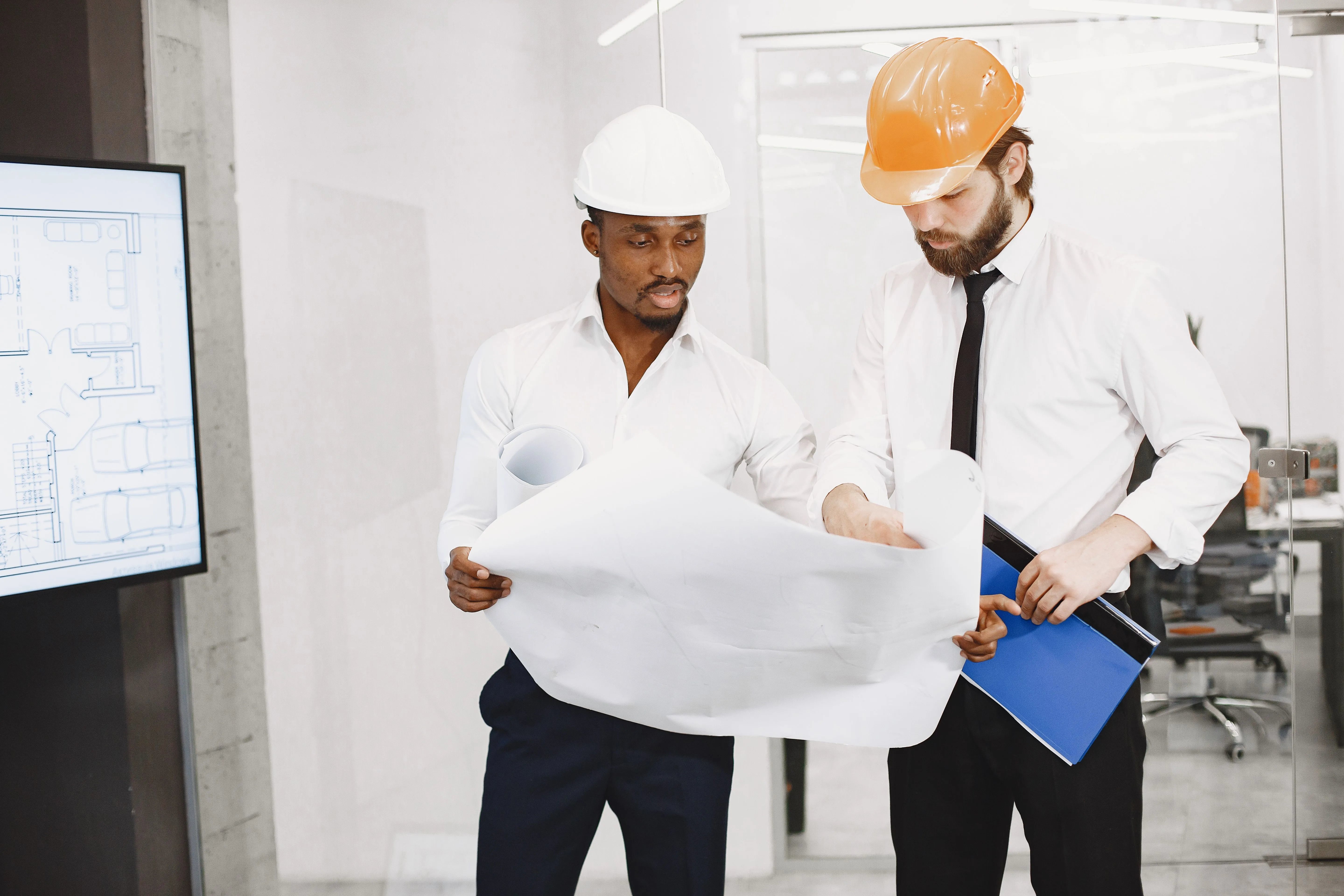 Construction consultants reviewing architectural drawings in an office
